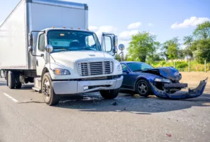 Truck accidents 9 Collision between a semi-truck and a blue sedan showing significant front-end damage on the sedan, highlighting the need for expert legal representation in truck accidents in Los Angeles.