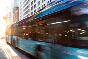 A city bus in motion on a bustling Los Angeles street at sunset, representing the dynamic environment where bus accidents can occur, highlighting the need for legal expertise in such cases.